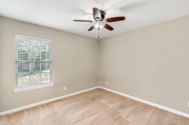 carpeted spare room featuring ceiling fan and a textured ceiling