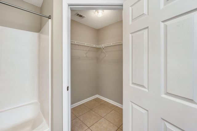 spacious closet with light tile patterned floors