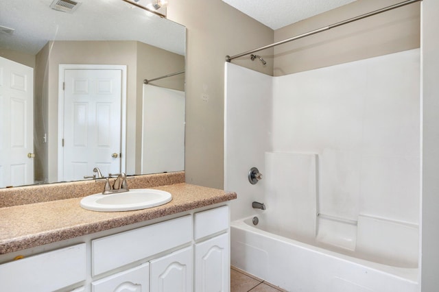 bathroom featuring tile patterned flooring, a textured ceiling, vanity, and shower / bath combination