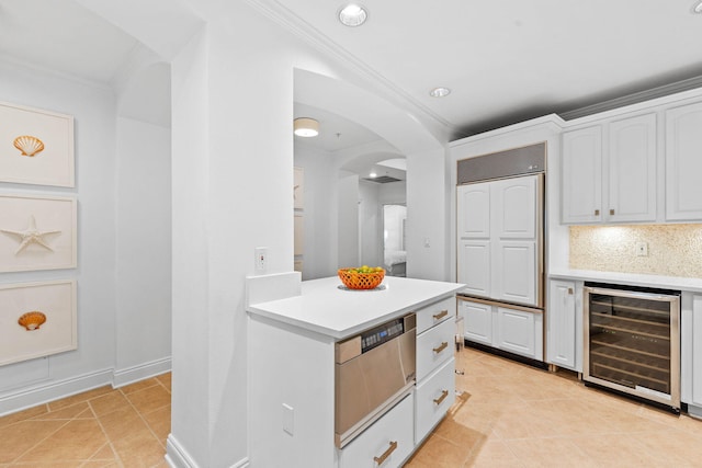 kitchen with tasteful backsplash, wine cooler, crown molding, and white cabinets