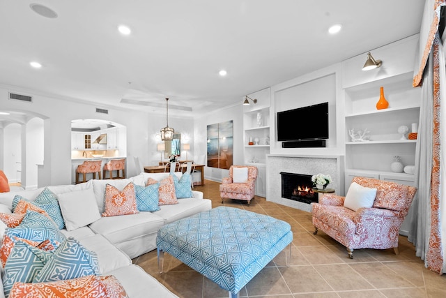 living room with built in shelves and light tile patterned flooring