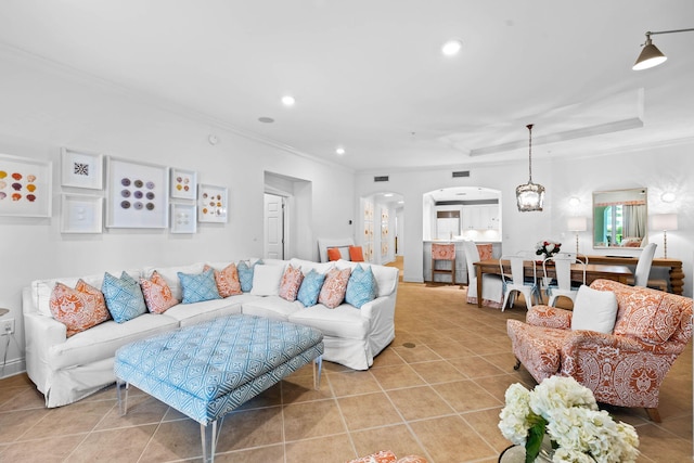 tiled living room featuring a chandelier, crown molding, and a tray ceiling