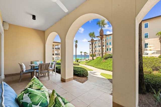 view of patio featuring ceiling fan and a water view