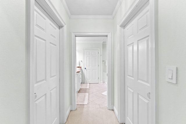 hallway with light tile patterned floors and ornamental molding