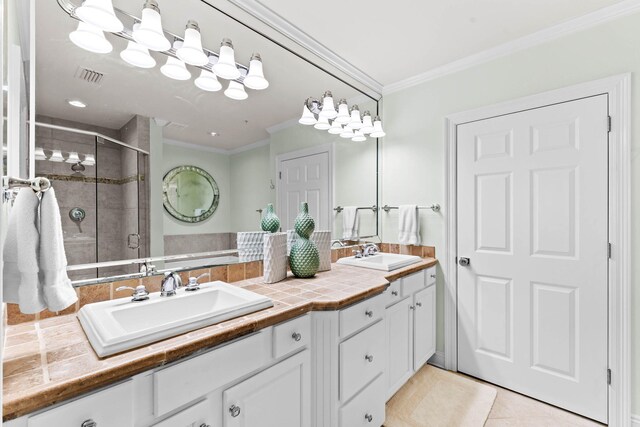 bathroom featuring tile patterned flooring, vanity, a shower with shower door, and crown molding