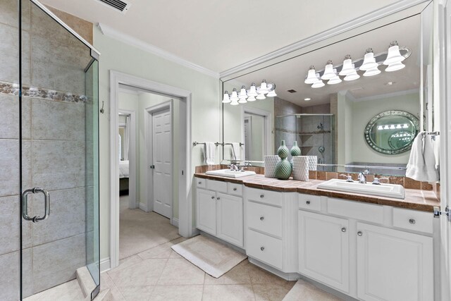 bathroom featuring tile patterned floors, vanity, a shower with door, and crown molding