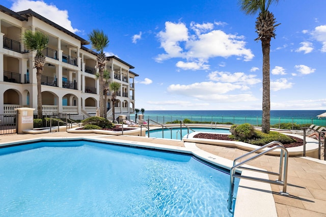 view of pool featuring a patio area and a water view