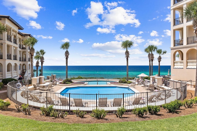 view of pool featuring a water view and a patio