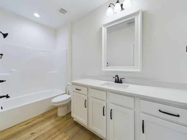 full bathroom with wood-type flooring, washtub / shower combination, vanity, and toilet