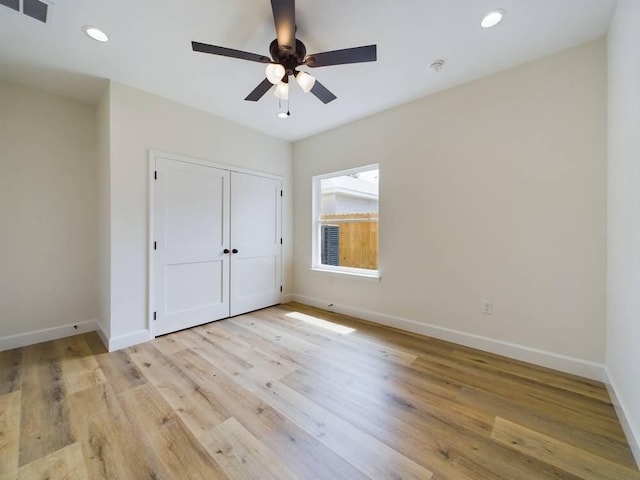 unfurnished bedroom with ceiling fan, light hardwood / wood-style flooring, and a closet