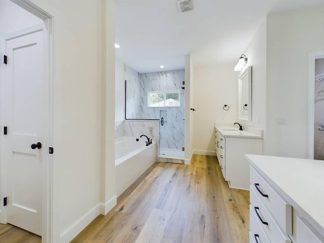 bathroom featuring shower with separate bathtub, vanity, and hardwood / wood-style flooring