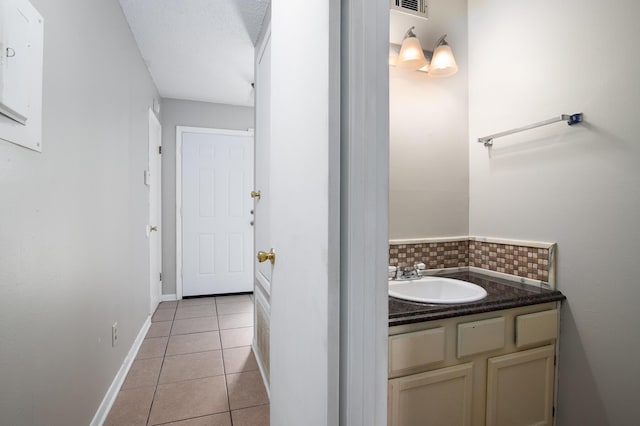 bathroom featuring vanity, tile patterned flooring, decorative backsplash, and a textured ceiling