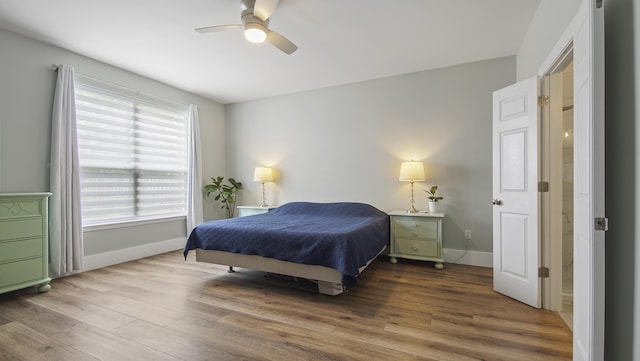 bedroom with ceiling fan, wood finished floors, and baseboards