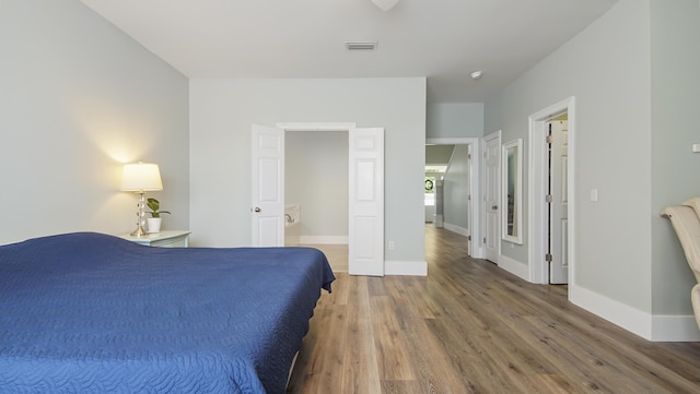 bedroom with wood-type flooring and connected bathroom