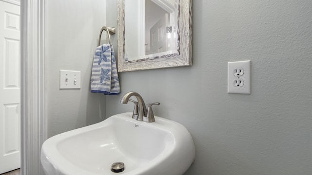 bathroom with a textured wall and a sink