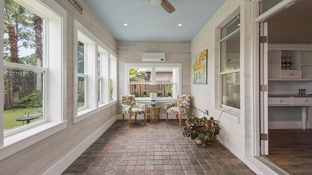 sunroom with a wall mounted air conditioner and ceiling fan