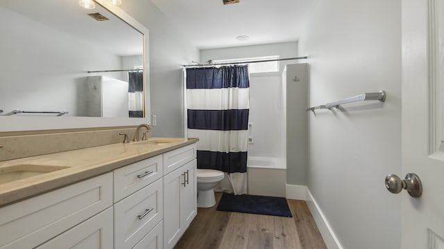 full bathroom featuring double vanity, shower / bath combination with curtain, a sink, and wood finished floors