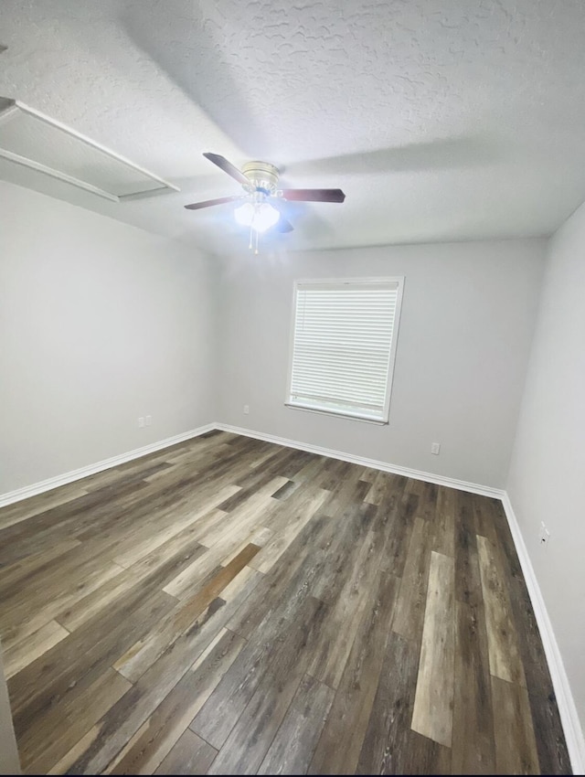 empty room featuring dark wood-type flooring and a textured ceiling