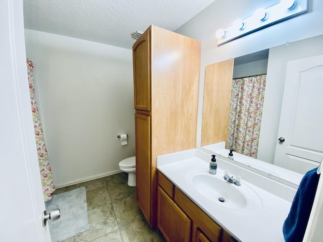 bathroom with toilet, a textured ceiling, and vanity