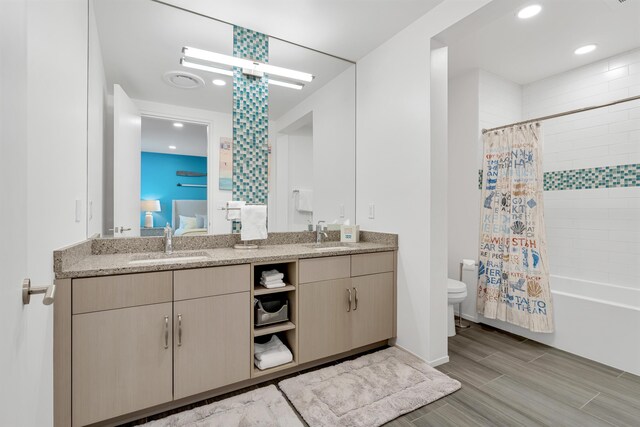 full bathroom with shower / tub combo, dual vanity, tile patterned floors, and toilet