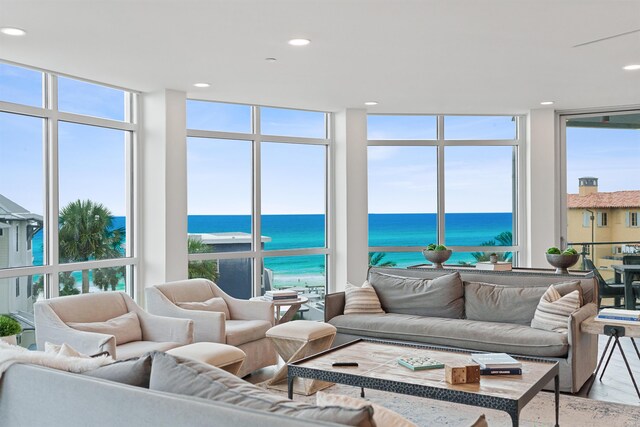 living room with a wall of windows, wood-type flooring, and a water view