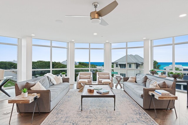 sunroom / solarium with a water view, ceiling fan, and plenty of natural light