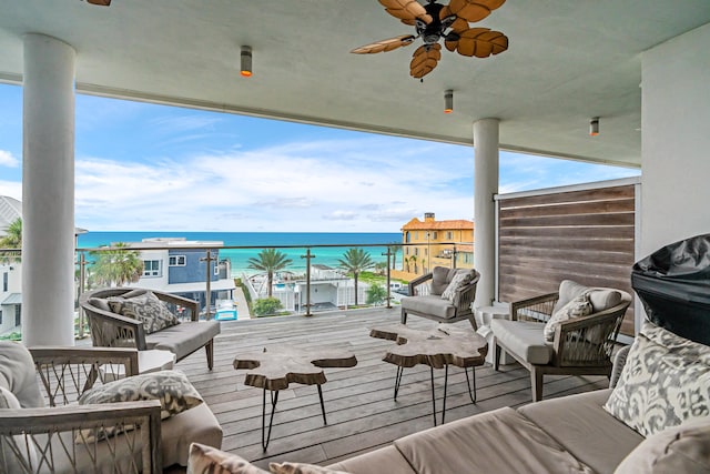 balcony featuring an outdoor living space, ceiling fan, and a deck with water view