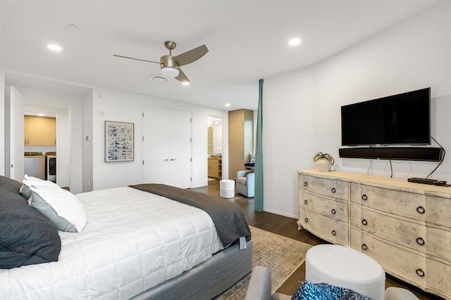 bedroom featuring washing machine and clothes dryer, ensuite bath, dark hardwood / wood-style floors, and ceiling fan