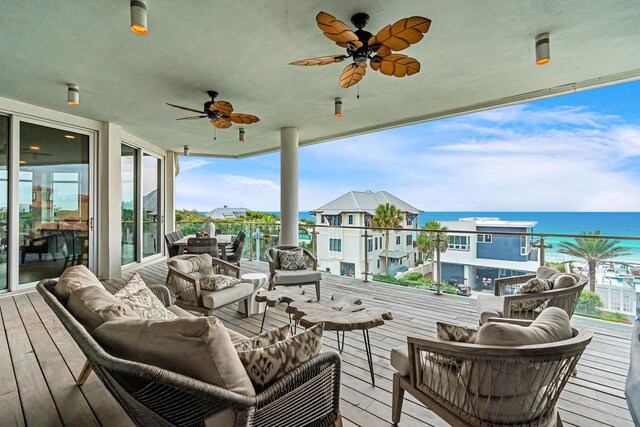 wooden deck with a water view, an outdoor hangout area, and ceiling fan