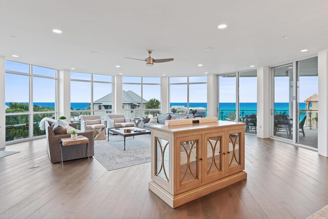 sunroom / solarium featuring a water view and ceiling fan