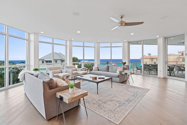 sunroom / solarium featuring a water view and ceiling fan