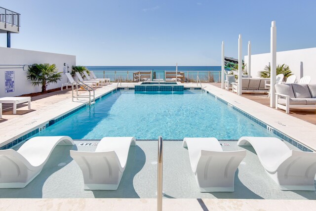 view of pool featuring a patio, a water view, and an outdoor living space