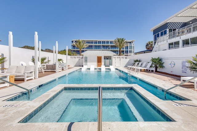 view of swimming pool featuring a patio area and a hot tub