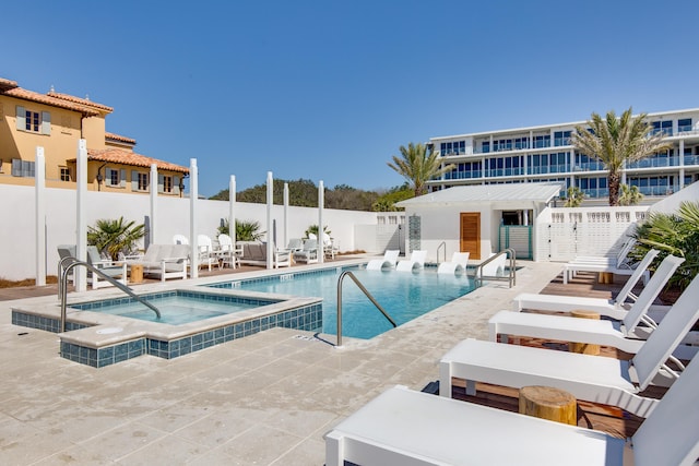 view of pool featuring a hot tub and a patio area