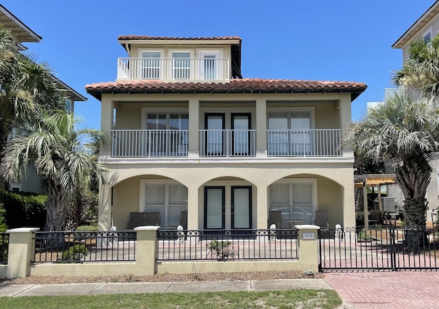 mediterranean / spanish house with french doors and a balcony