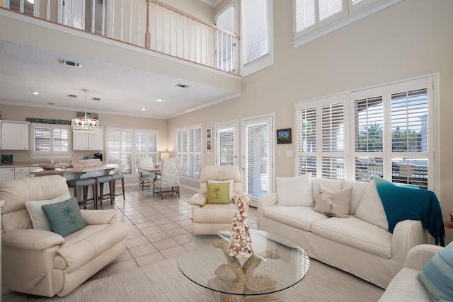 living room with an inviting chandelier, crown molding, sink, light tile patterned floors, and a towering ceiling