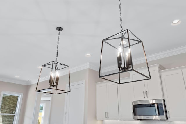 details with white cabinets, decorative light fixtures, an inviting chandelier, and crown molding