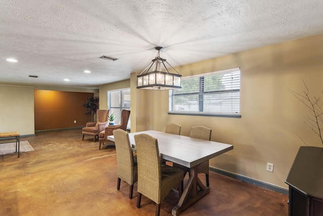 dining area with baseboards, visible vents, finished concrete flooring, and a textured ceiling