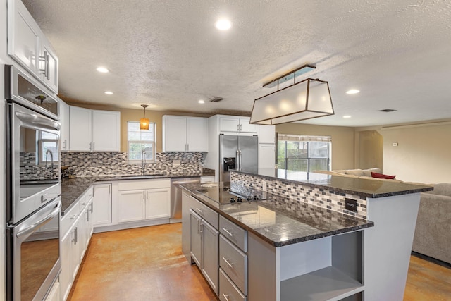 kitchen with open shelves, decorative backsplash, appliances with stainless steel finishes, open floor plan, and a kitchen island