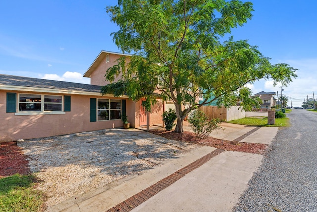 view of front facade featuring fence and stucco siding