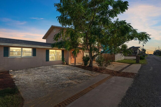 view of front facade featuring fence and stucco siding