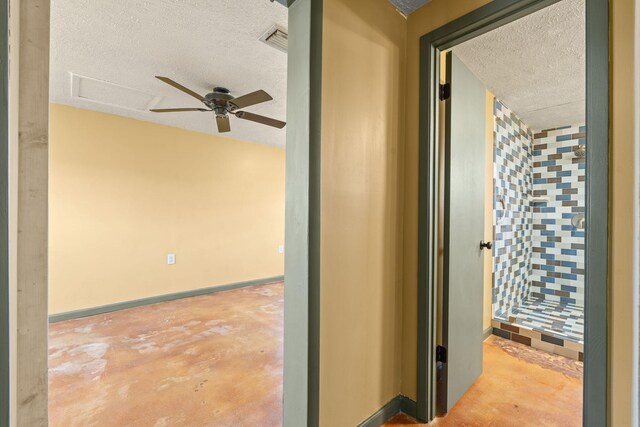 hallway with baseboards, concrete floors, visible vents, and a textured ceiling