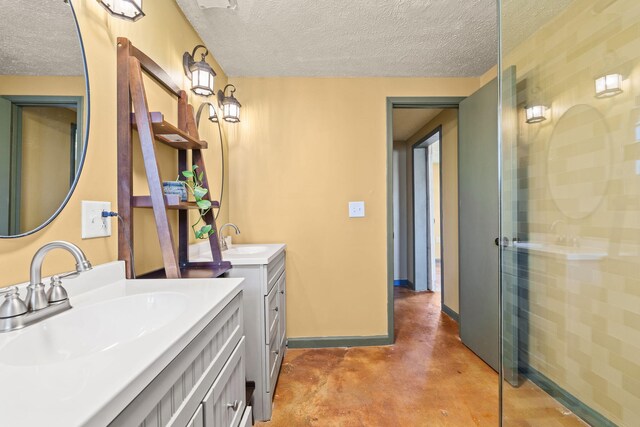 full bath featuring a textured ceiling, a stall shower, a sink, and concrete flooring