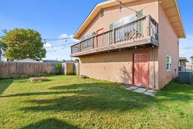 rear view of property featuring central AC unit, a lawn, fence, a deck, and stucco siding