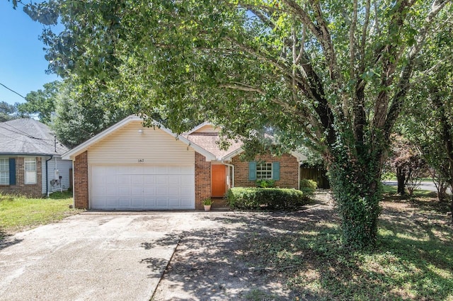 view of front of home with an attached garage, driveway, and brick siding