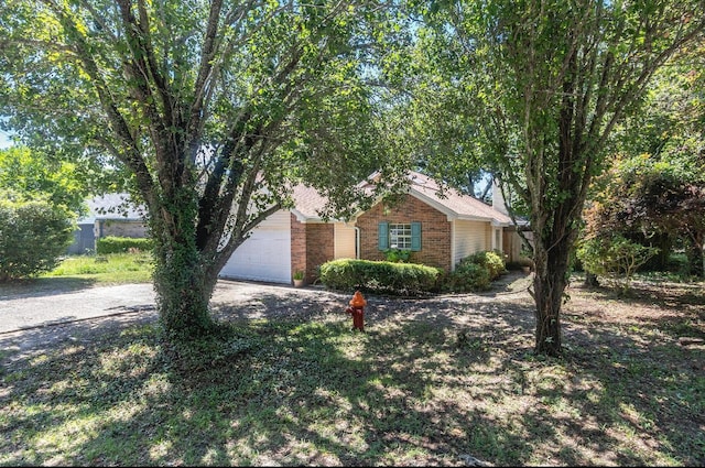 single story home featuring brick siding, driveway, and an attached garage