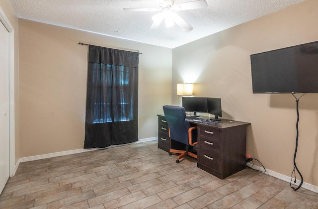 home office featuring a ceiling fan, baseboards, a textured ceiling, and light wood finished floors