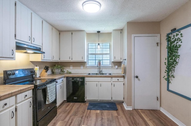 kitchen featuring black appliances, a sink, and white cabinets