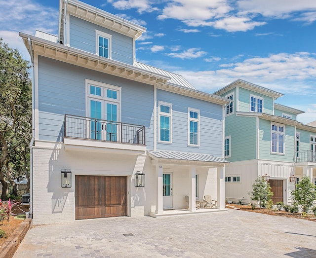 rear view of property with a balcony and a garage