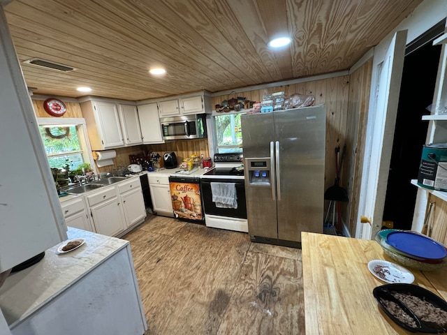 kitchen featuring white cabinets, appliances with stainless steel finishes, and wooden ceiling